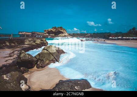 Die Schönheit des Klayar Beach mit seinen einzigartigen Korallensteinen und Kokospalmen entlang der Küste in Pacitan, Ost-Java, Indonesien Stockfoto