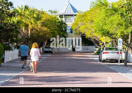 Seaside, USA - 25. April 2018: Strandgemeinschaft am Meer und Menschen, die Hunde an der Leine im Urlaub in Florida während sonnigen Tages zu Fuß Stockfoto