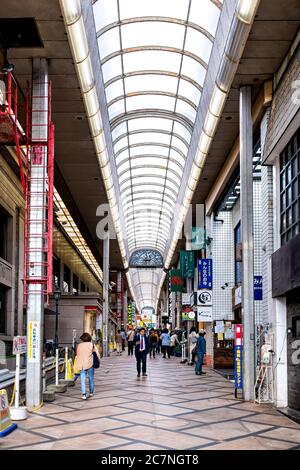 Nara, Japan - 15. April 2019: Menschen Touristen zu Fuß auf Straße überdachte Arkade in der Innenstadt Geschäfte und Schilder vertikalen Blick Stockfoto