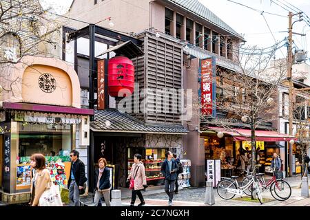 Nara, Japan - 15. April 2019: Menschen viele Touristen zu Fuß auf Bürgersteig Straße in der Innenstadt in Richtung Park mit Geschäften Geschäfte und Schilder Stockfoto