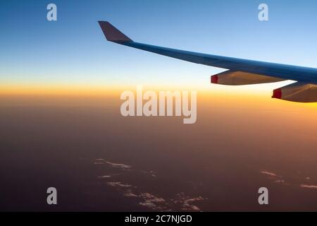 Blick vom Flugzeug während Sonnenuntergang zeigt Flugzeugflügel Stockfoto