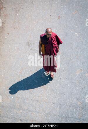 Ein Blick von oben auf einen buddhistischen Mönch, der auf einer Straße in Mandalay, Myanmar, unterwegs ist Stockfoto