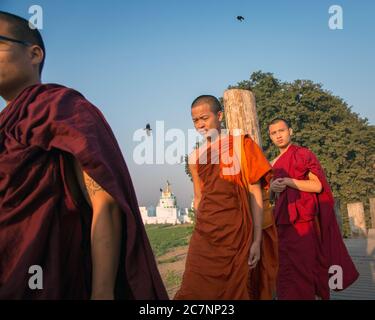 Drei junge Mönche gehen auf der U Bein Brücke in Mandalay, Myanmar Stockfoto