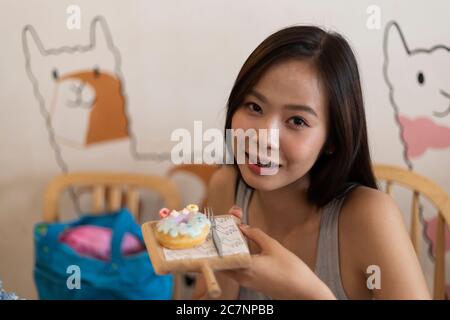 Junges Mädchen essen Donut in einer Cafeteria. Stockfoto