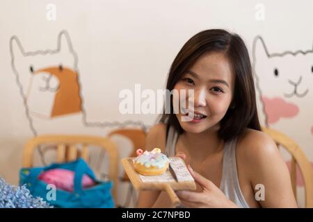 Junges Mädchen essen Donut in einer Cafeteria. Stockfoto