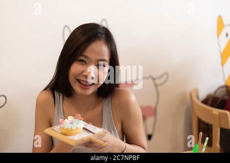 Junges Mädchen essen Donut in einer Cafeteria. Stockfoto