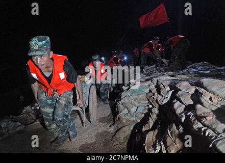 Peking, Chinas Provinz Jiangxi. Juli 2020. Bewaffnete Polizisten bringen Sandsäcke auf dem Damm im Bezirk Poyang, ostchinesische Provinz Jiangxi, 17. Juli 2020. Quelle: Wan Xiang/Xinhua/Alamy Live News Stockfoto