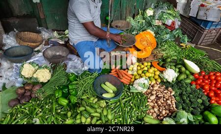 Frisches grünes Gemüse auf dem Display zum Verkauf mit Blick auf Der Ladenbesitzer in einem lokalen Markt in Kalkutta Indien Stockfoto