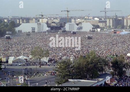 FILED - 21. Juli 1990, Berlin: Zuschauer stehen auf dem ehemaligen Todesstreifen am Potsdamer Platz und warten auf die Roger Waters Produktion des Pink Floyd Erfolges 'The Wall'. (Zu 'Rockspektakel auf Todesstreifen - 'die Mauer' vor 30 Jahren in Berlin') Foto: Peter Kneffel/dpa Stockfoto