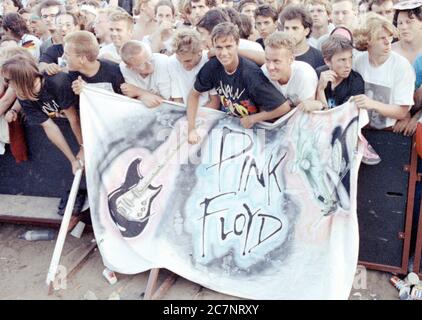 FILED - 21. Juli 1990, Berlin: Zuschauer stehen auf dem ehemaligen Todesstreifen am Potsdamer Platz und warten auf die Roger Waters Produktion des Pink Floyd Erfolges 'The Wall'. (Zu 'Rockspektakel auf Todesstreifen - 'die Mauer' vor 30 Jahren in Berlin') Foto: Wolfgang Kumm/dpa Stockfoto