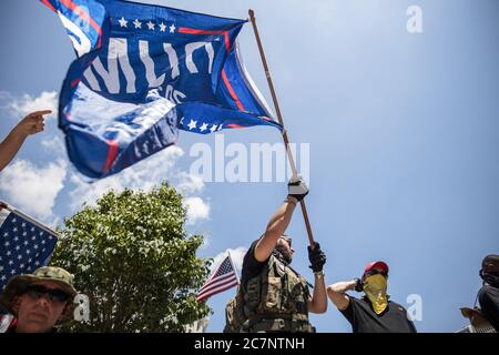 Columbus, Usa. Juli 2020. Ein Trump-Unterstützer schwenkt eine Flagge während einer Anti-Maske-Kundgebung im Ohio State House.über 200 Menschen versammelten sich im Ohio State House, um gegen das Mandat der Gesichtsmaske zu protestieren, das mehrere Landkreise im Bundesstaat unterstehen. Kredit: SOPA Images Limited/Alamy Live Nachrichten Stockfoto