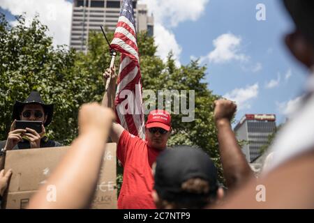 Columbus, Usa. Juli 2020. Ein Trump-Unterstützer schwenkt eine Flagge während einer Anti-Maske-Kundgebung im Ohio State House.über 200 Menschen versammelten sich im Ohio State House, um gegen das Mandat der Gesichtsmaske zu protestieren, das mehrere Landkreise im Bundesstaat unterstehen. Kredit: SOPA Images Limited/Alamy Live Nachrichten Stockfoto