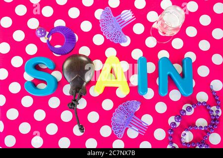 Overhead erschossen Plastikbuchstaben und Kastagnetten Schreibweise [SPANIEN} lila Ornamente Rosa gepunkteter Hintergrund Stockfoto