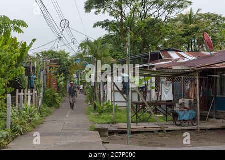 Wanderweg mit unbekannten Menschen im Dorf Tortuguero bei Regenwetter, Costa Rica Stockfoto