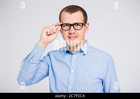 Porträt eines Geschäftsmannes in Brillen Blick auf Kamera über grauen Hintergrund Stockfoto