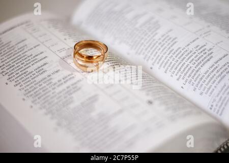 Nahaufnahme von zwei goldenen Ringen auf einem geöffneten Buch- Heiratskonzept Stockfoto
