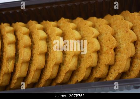 Süßes, goldenes Shortbread, Butterkekse, Gebäck mit süßen Füllungen, Milch und Schokoladenpaste in Form von Yang und Yin auf einem weißen befindet. Stockfoto