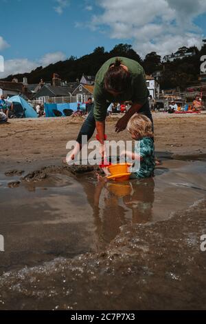 Blonde Kleinkind am Strand in Lyme Regis, Dorest, Großbritannien Stockfoto