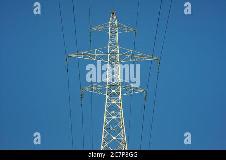 Einzelne Hochspannungs-Strom Pylon oder Übertragung Turm und Hochspannungsleitungen niedrigen Winkel Ansicht gegen klaren blauen Himmel als Energie-Thema. Stockfoto