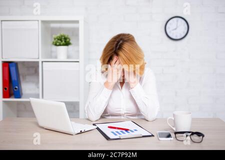 Depression Konzept - gestresst reifen Geschäftsfrau sitzen im Büro Stockfoto