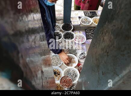 Kathmandu, Nepal. Juli 2020. Eine nepalesische Frau wählt am 19. Juli 2020 auf dem lokalen Markt auf dem Ghantakarna-Festival in Kathmandu, der Hauptstadt Nepals, Ringe aus. Die Newar-Gemeinde des Kathmandu-Tals beobachtet Ghantakarna, ein Fest, um böse Geister zu vertreiben und Glück zu bringen. Menschen tragen Metallringe, um sich vor allen Übel und bösen Geistern zu schützen. Kredit: Sunil Sharma/ZUMA Wire/Alamy Live Nachrichten Stockfoto