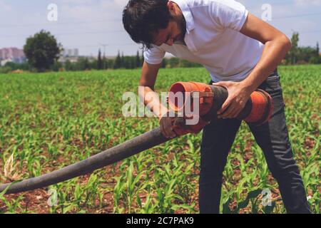 Landwirtschaft, Landwirt in Maisfeld fix Bewässerungssystem Stockfoto