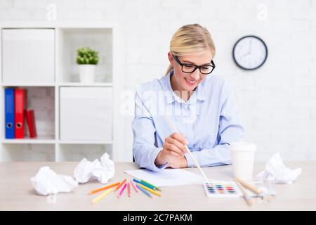 Kreativität, Idee und Inspiration Konzept - Mädchen malen etwas zu Hause oder im Büro Stockfoto