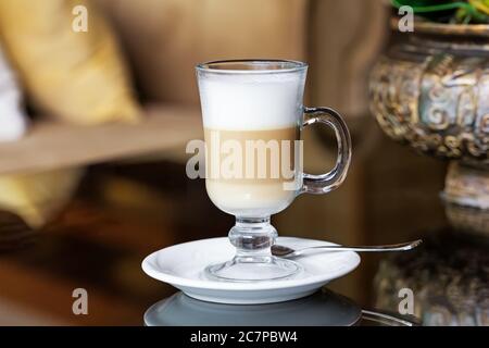 Heißer Kaffee Latte in hohem Glas auf einem Tisch Stockfoto