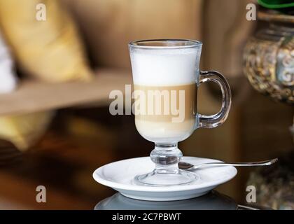 Heißer Kaffee Latte in hohem Glas auf einem Tisch Stockfoto