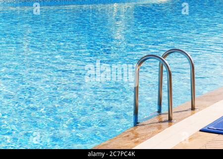 Blauer Swimmingpool mit Treppe im Luxushotel Stockfoto