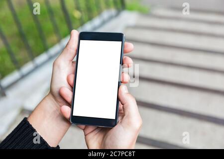 Mann nutzt sein Handy im Freien, Nahaufnahme. Bild von jungen Mann mit Handy auf der Bank sitzen. Stockfoto