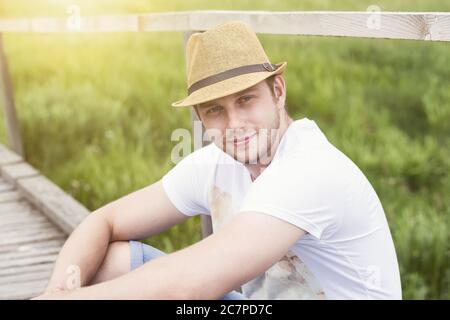 Nahaufnahme Porträt von lächelnd schönen Mann sitzt im Freien Stockfoto