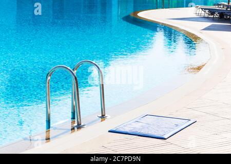 Blauer Swimmingpool mit Treppe im Luxushotel Stockfoto