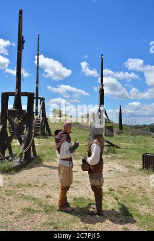 LES BAUX, FRANKREICH - JUL 9, 2014: Zwei Schauspieler, die als mittelalterliche Krieger verkleidet sind, führen die Show in der Nähe der Katapulte auf. Les Baux ist nun völlig Th übergeben Stockfoto