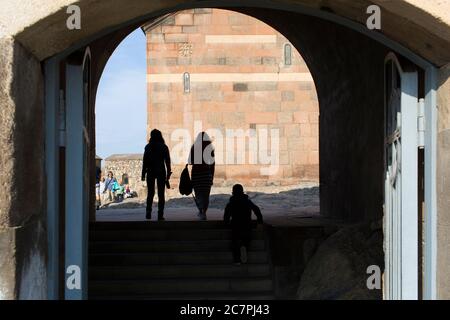 Touristen und Besucher werden Führungen durch das Innere von St. Astvatsatsin in Khor Virap gegeben, während Priester über ihre tägliche Arbeit gehen. Armenien Stockfoto