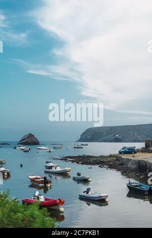 CADAQUES, SPANIEN - 21. Aug 2019: Blick auf Boote, die an der felsigen Küste mit bewölktem Himmel in Cadaques, Spanien, verankert sind Stockfoto