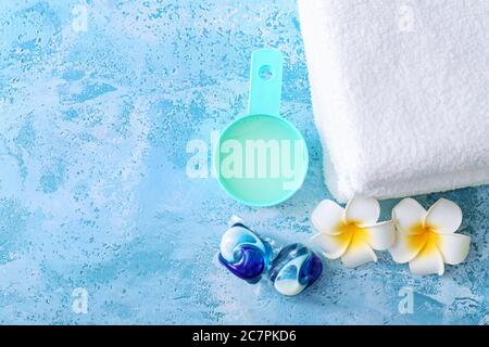 Waschmittel und Handtücher auf farbigem Hintergrund Stockfoto