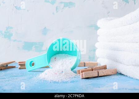 Waschmittel mit Handtüchern und Haken auf farbigem Hintergrund Stockfoto