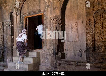 Touristen und Besucher werden Führungen durch das Innere von St. Astvatsatsin in Khor Virap gegeben, während Priester über ihre tägliche Arbeit gehen. Armenien Stockfoto