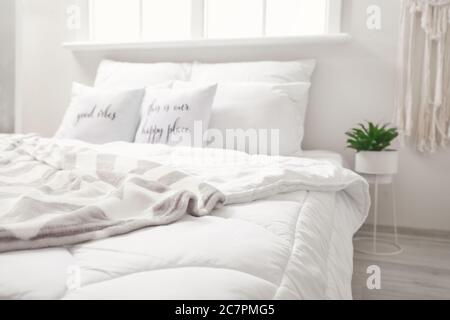 Großes bequemes Bett im Zimmer Stockfoto