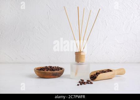 Reed Diffusor und Kaffeebohnen auf dem Tisch im Zimmer Stockfoto