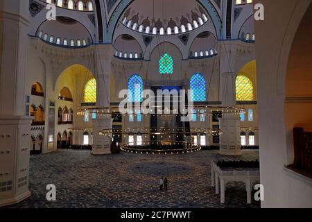 Licht leuchtet durch die exquisiten Buntglasfenster zum prachtvollen mit Teppich ausgelegten Hauptgebetssaal der Camlica Camii in Istanbul. Stockfoto