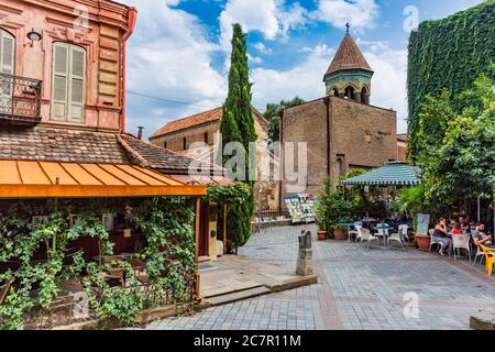Tiflis, Georgien - 25. August 2019: Touristen, die ein Restaurant in einer Straße des historischen Stadtzeichens der georgischen Hauptstadt Tiflis in Osteuropa genießen Stockfoto