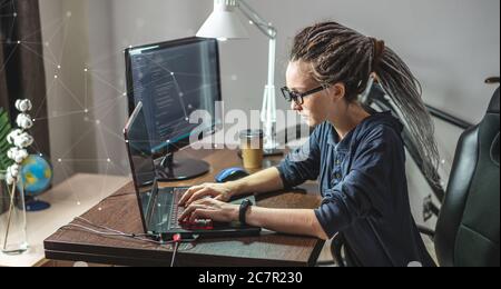Moderne junge weibliche Programmierer ist das Schreiben von Programmcode auf einem Laptop zu Hause. Remote-Arbeit im IT-Bereich. Das Konzept der Softwareentwicklung. Stockfoto