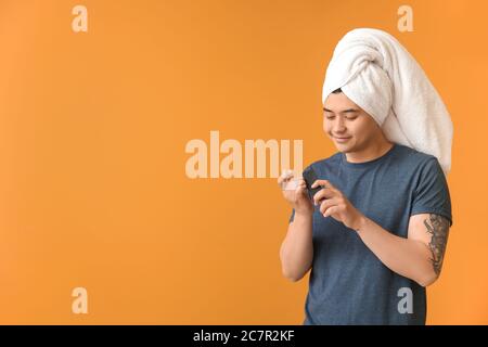 Lustige asiatische Mann tun Maniküre auf Farbe Hintergrund Stockfoto