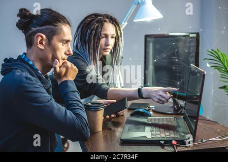 Programmierer entwickeln Software, indem sie mit Software-Code zusammen arbeiten. Teamarbeit. Moderne Arbeit eines IT-Ingenieurs. Stockfoto