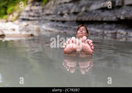 Frau schwimmt im Fluss in natürlichen Pool Stockfoto