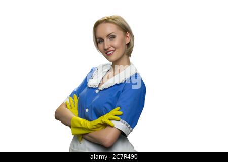 Lächelndes blondes Mädchen in gelben Gummihandschuhen mit gekreuzten Armen auf weißem Hintergrund. Stockfoto