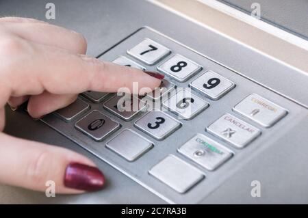 Nahaufnahme einer weiblichen Fingerpressung Tasten auf einem Tastatur für Geldautomaten Stockfoto