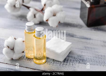 Flaschen Baumwollsaatenöl mit Kosmetikpads auf dem Tisch Stockfoto